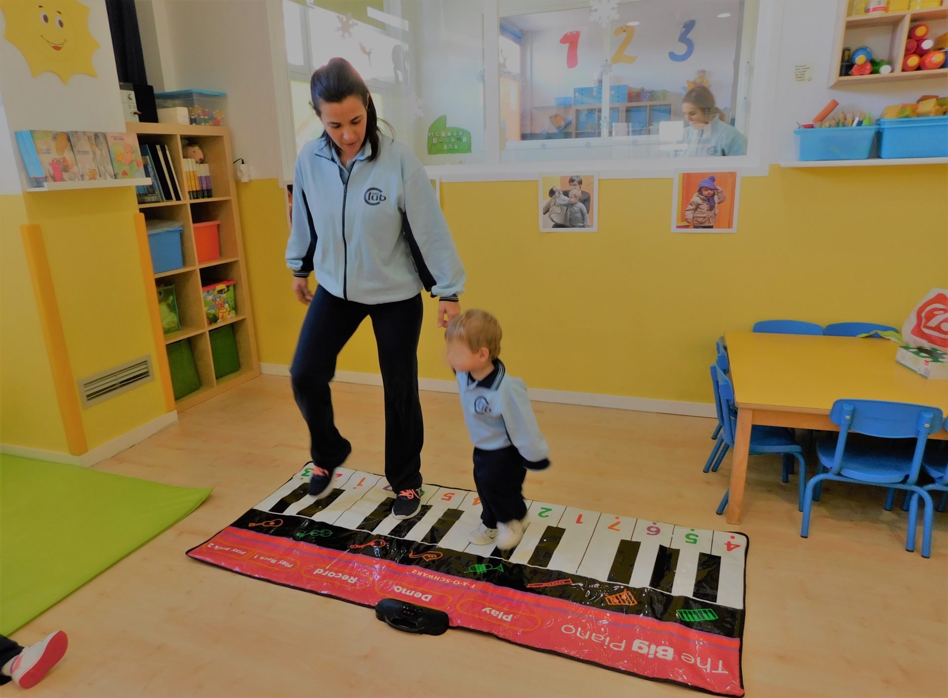 Maestra y Niño jugando con juguetes de Piano